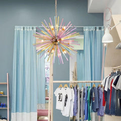 A room with blue curtains and clothing racks, featuring a colorful starburst pendant light hanging from the ceiling.