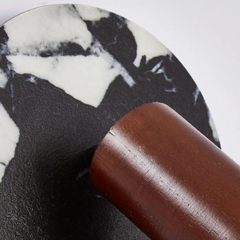 Marble-patterned coaster with a wooden handle on a white background