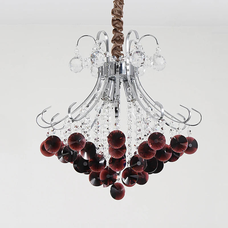 A detailed view of the crystal and wine red elements of the chandelier against a plain background.