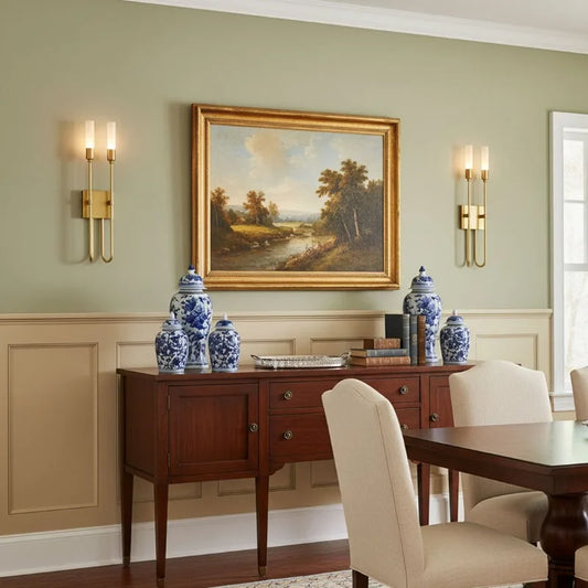 A contemporary gold metal wall sconce with a curved arm and a frosted acrylic cylinder shade, mounted on a pale green wall.