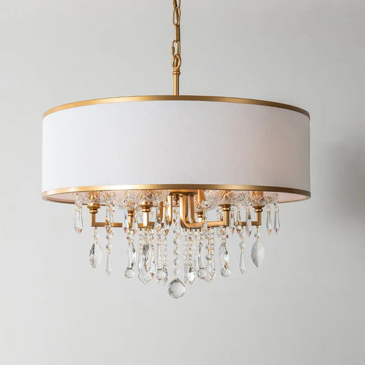 Gold drum shade chandelier with cascading clear crystals against a white background.