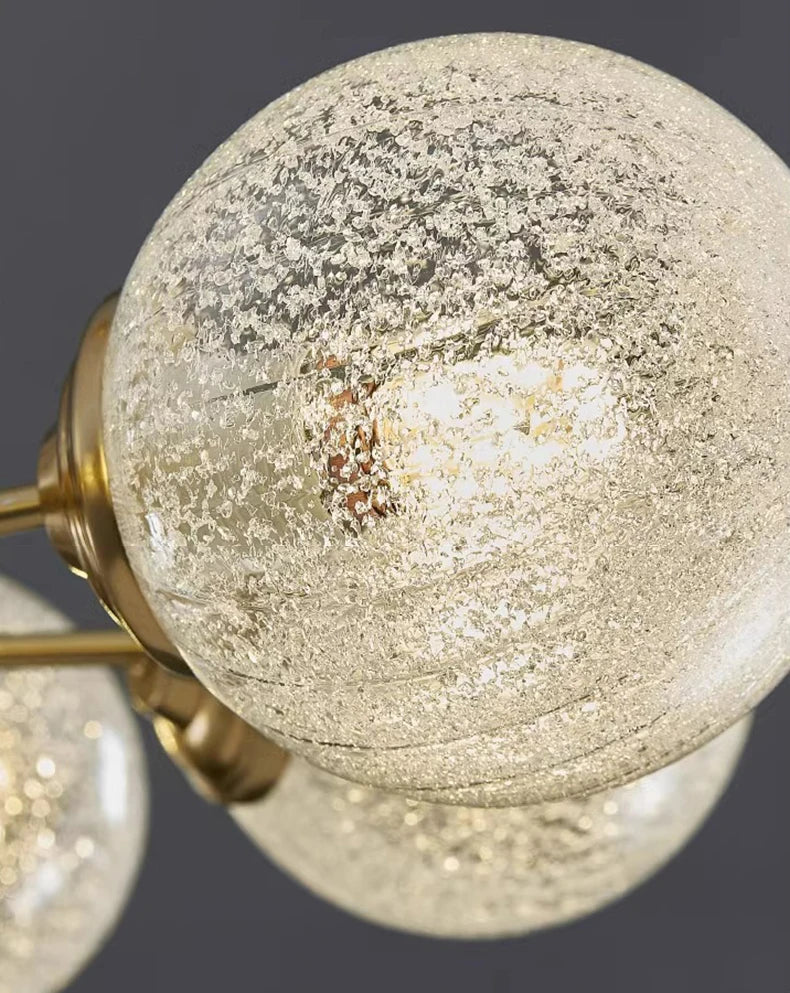 Close-up of a textured glass light bulb with gold fixture on a dark background