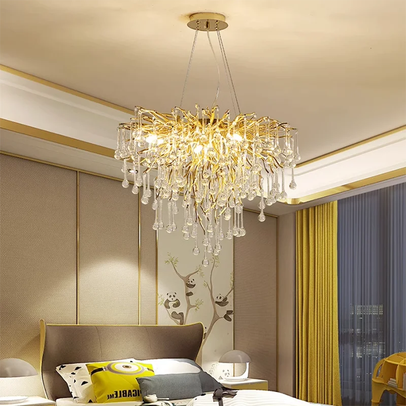 Chandelier hanging in a bedroom with a bed and decorative pillows.