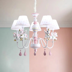Unicorn chandelier installed in a room with pastel pink and green walls.