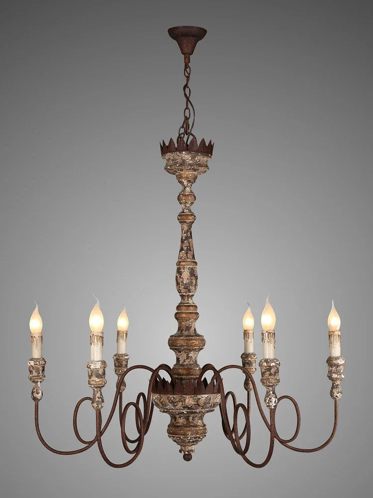 Close-up view of the distressed wood and iron candle-style chandelier, highlighting its ornate details.