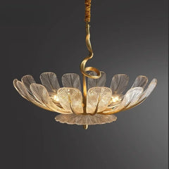 Gold leaf floral chandelier with clear glass petals hanging from a dark background.