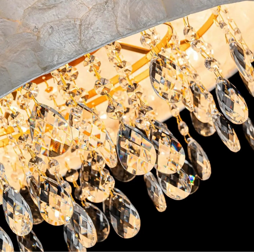 Close-up of a chandelier with crystal details on a dark background, featuring the 'artpad' brand.