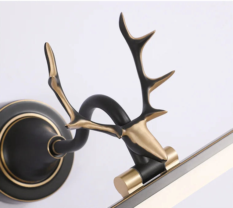 Decorative wall sconce with deer antlers on a white background