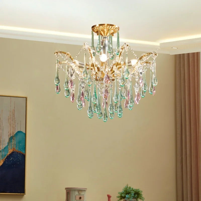 View of a gold crystal chandelier with pink and green teardrop accents, mounted on a ceiling.