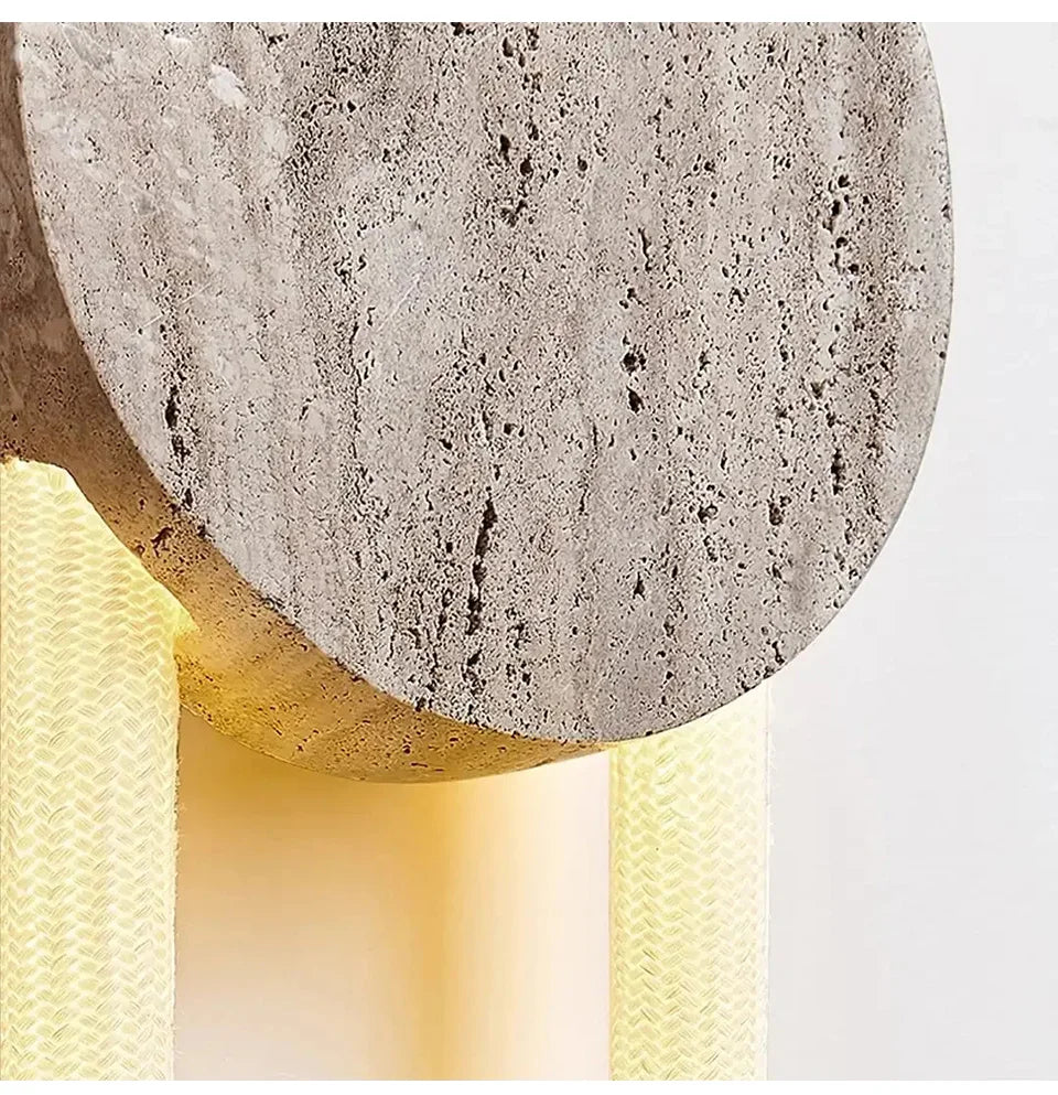 Detailed view of the textured stone material used in the wall sconce, with a glimpse of the yellow LED light.