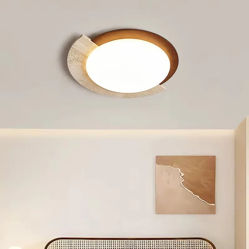 Ceiling light fixture on a neutral wall with a painting in the corner