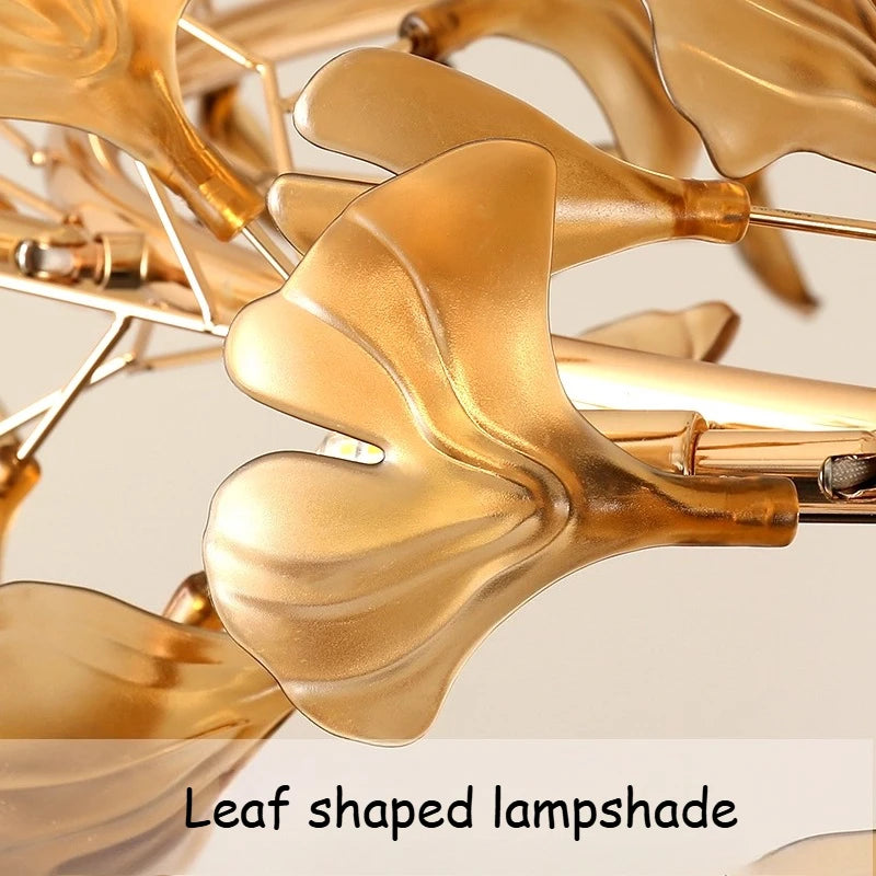 Detailed view of the leaf-shaped lampshade on the gold chandelier.