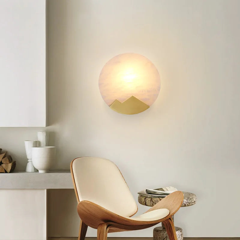 Modern interior with a wooden chair, round table, and wall-mounted light fixture.