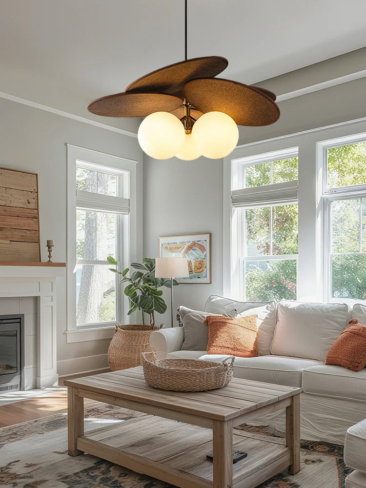 Living room with a modern chandelier, sofa, coffee table, and large windows.