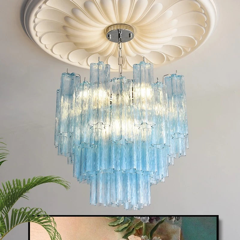 A close-up view of a tiered chandelier with translucent blue glass rods hanging from a chrome base, showing the light diffusion.
