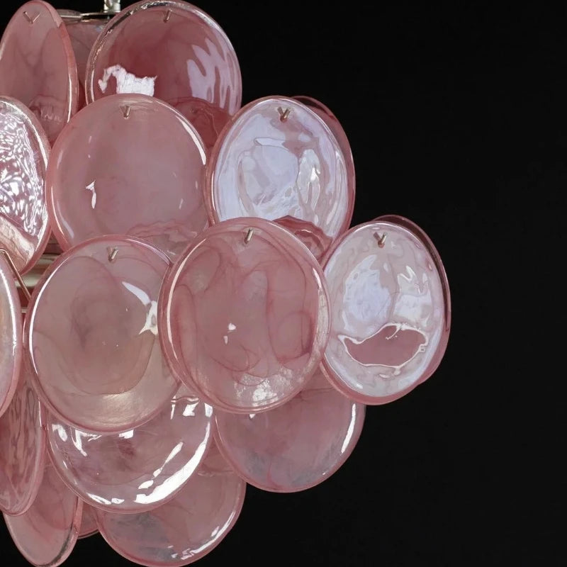 Close-up view of the pink glass discs on a chandelier.