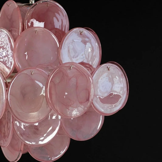Close-up view of the pink glass discs on a chandelier.