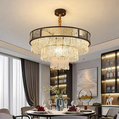 Tiered crystal chandelier with a dark frame and clear crystal droplets, installed in a dining room setting.