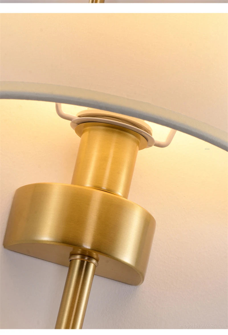 Close-up of a gold lamp fixture with a white shade.