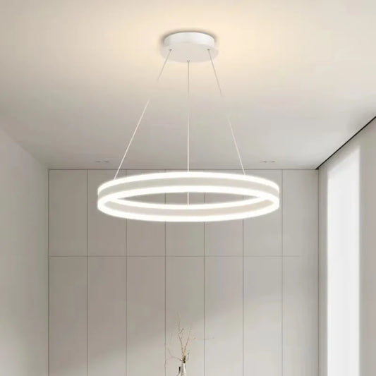 White ring pendant light with a minimalist design, illuminated in a bright white setting.