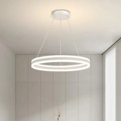 White ring pendant light with a minimalist design, illuminated in a bright white setting.
