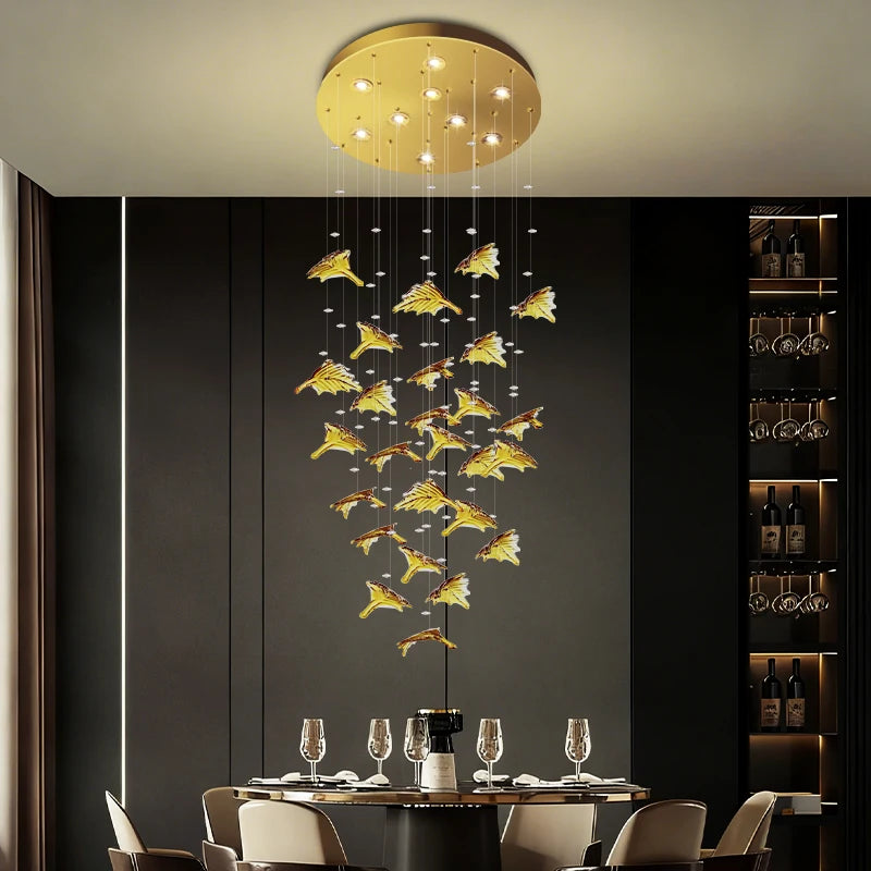 Modern chandelier with gold accents hanging above a dining table in a stylish room.