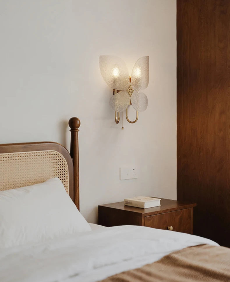 Bedroom with wooden headboard, nightstand, and wall sconce.