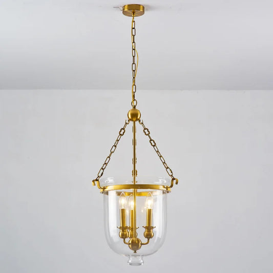 Polished copper and clear glass drum pendant light hanging from a chain against a white ceiling