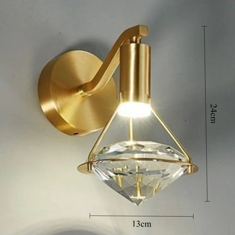 Gold wall-mounted light fixture with crystal design on a gray background