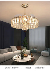A gold and crystal tiered semi-flush ceiling light with fan blades extended, installed in a modern living room setting.