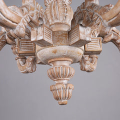 Close-up view of the central column and lower decorative elements of the distressed wood chandelier.