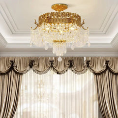 View of a gold semi-flush crystal ceiling light above a window with luxurious brown drapes and sheer curtains.