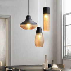 Three pendant lights with ribbed glass shades hanging in a well-lit room with a window.