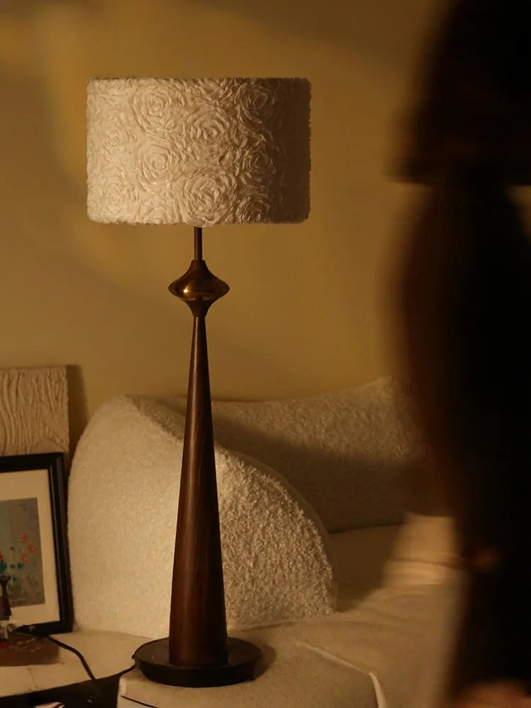 Close-up of the textured floral pattern on the drum shade of a dark grey floor lamp.