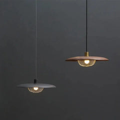 Comparison of two pendant lights, one with a wood finish and gold cage, the other with a dark finish and gold cage.