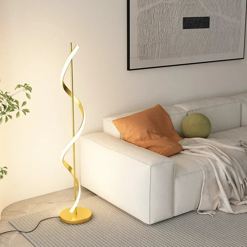 Gold spiral floor lamp in a living room setting with a sofa and decorative pillows.