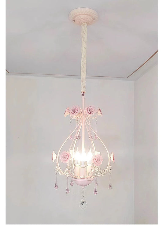 Close-up view of the pink crystal chandelier with rose details and hanging prisms.