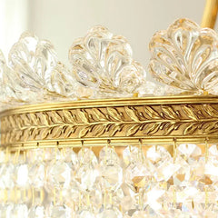 Close-up view of the top decorative elements and crystal strands of a gold chandelier.