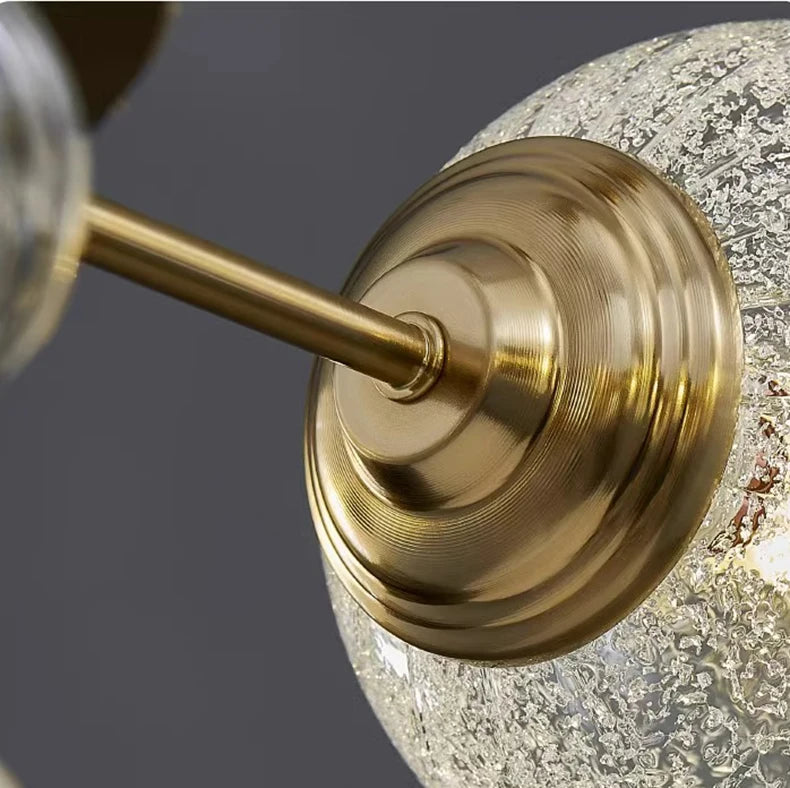 Close-up of a gold fixture with a textured glass shade on a dark background