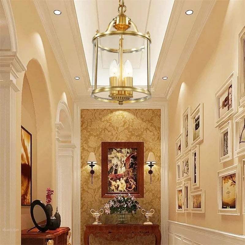 Gold lantern pendant light in a hallway with ornate wallpaper and a collection of framed pictures on the wall.