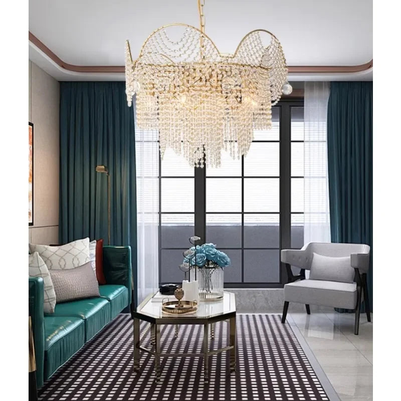 A modern living room featuring a gold cascading crystal chandelier hanging above a glass coffee table.