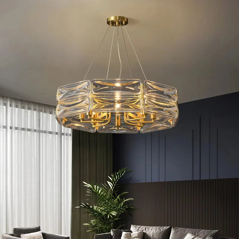 A gold and crystal chandelier with stacked cube-shaped crystals hanging in a contemporary living room setting.