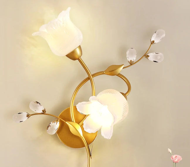 Decorative wall light fixture with gold finish and glass shades on a beige background