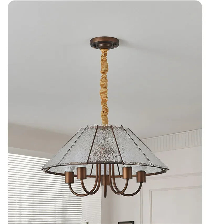 A brushed gold pendant light with a conical frosted glass shade, revealing its internal structure and light sources.