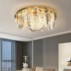 Gold floral wave LED ceiling light with acrylic diffusers mounted on a white ceiling in a modern living room.