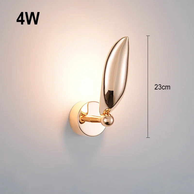 Gold wall light fixture with leaf design on a gray background, showing wattage and dimensions.