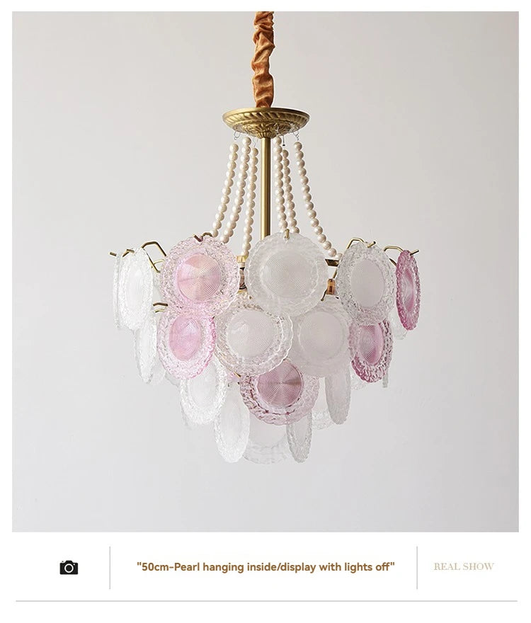 Decorative chandelier with pink and white glass elements on a plain background