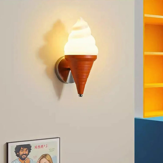 An ice cream cone wall sconce glowing warmly on a beige wall next to yellow shelves.