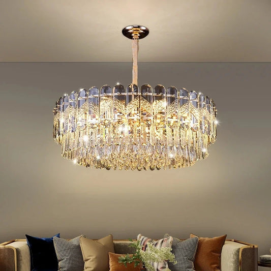 A luxurious tiered gold crystal chandelier with cascading teardrop crystals, illuminating a modern living room.