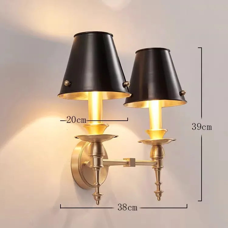 Wall-mounted lamp with black shades and gold base, showing dimensions on a neutral background.